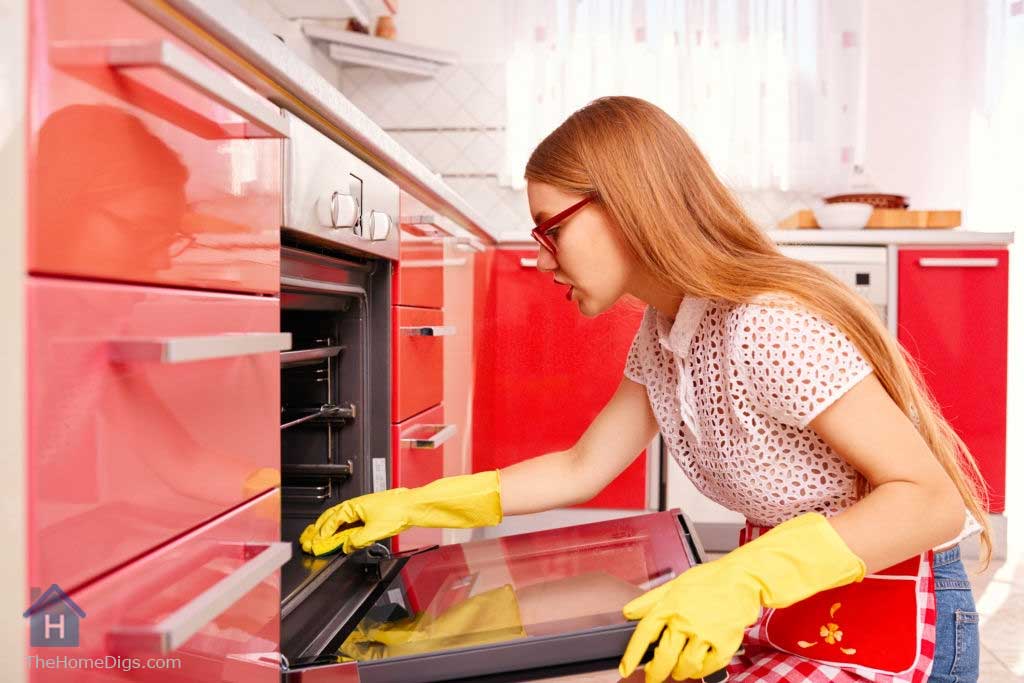 a young girl cleaning the oven red decor kitchen