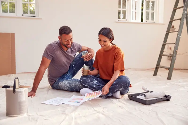 Happy couple painting their new home