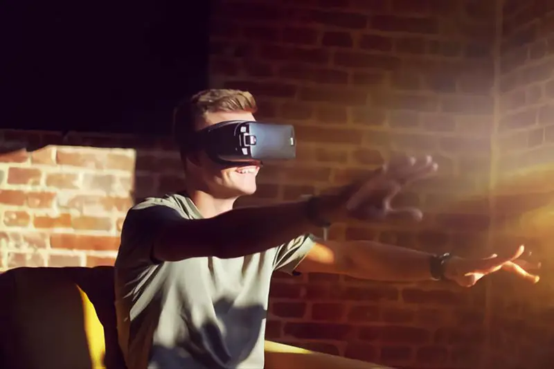 Young-man-enjoying-vr-set-sitting-on-sofa